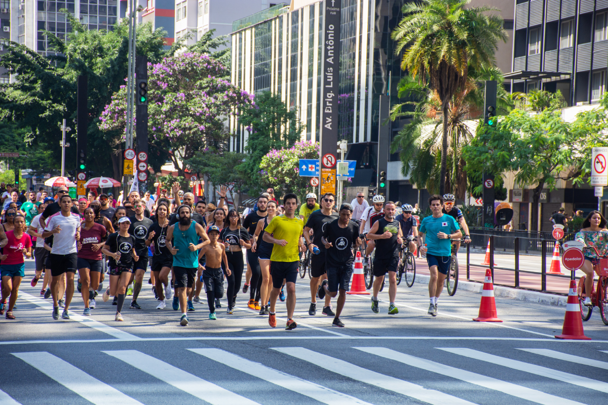 Pessoas correndo a São Silvestre, cruzando a Avenida Paulista.
